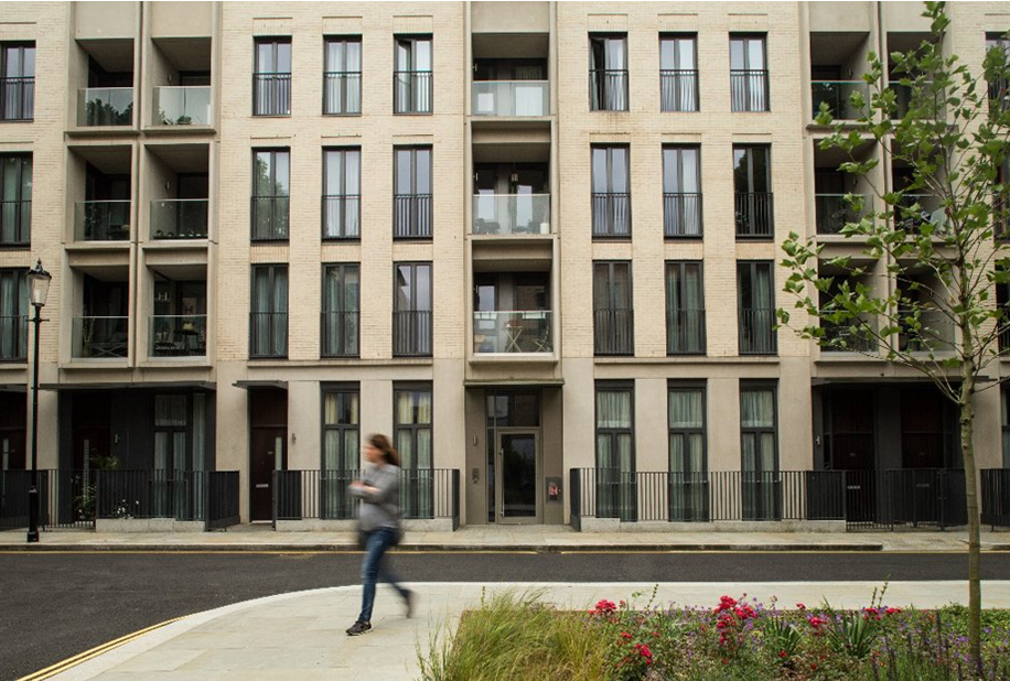 An image of a women walking in front of a building