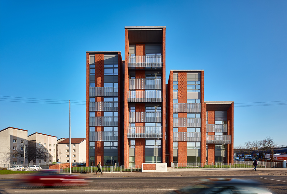 An image of a man walking in front of a building